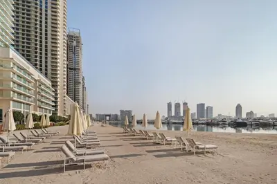 a row of chairs and umbrellas on a beach at 4BR Beachfront Marina & Palm View in Dubai