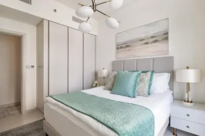 a bedroom with a large bed with blue pillows at 4BR Beachfront Marina & Palm View in Dubai