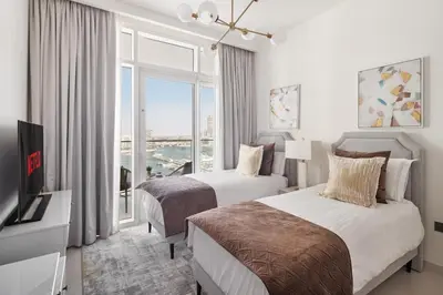 a hotel room with two beds and a television at 4BR Beachfront Marina & Palm View in Dubai