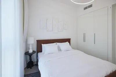 a white bedroom with a bed with white sheets at Cozy 1BR Burj Crown Downtown in Dubai