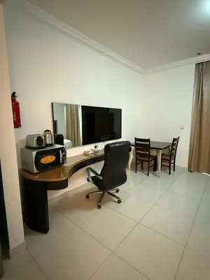 a room with a desk with a computer and a table at Capital Bay city view Studio in Dubai