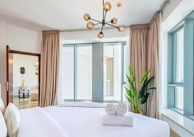 a bedroom with a white bed with a large window at Exceptional 1BR I Burj Khalifa I Fountain View in Dubai