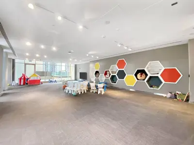 a large room with tables and a wall with colorful hexagons at On the dock Nice 1bedroom in Dubai Creek Harbour in Dubai