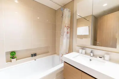 a bathroom with a tub and a sink and a bath tubermott at On the dock Nice 1bedroom in Dubai Creek Harbour in Dubai