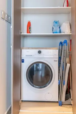 a washer and dryer in a room with shelves at On the dock Nice 1bedroom in Dubai Creek Harbour in Dubai