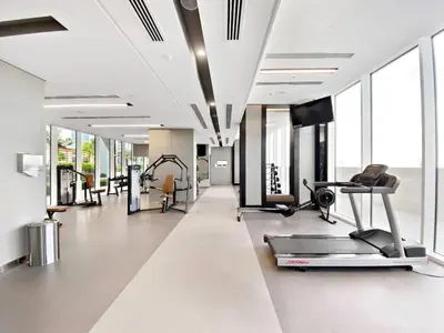 a gym with a treadmill and a flat screen tv at On the dock Nice 1bedroom in Dubai Creek Harbour in Dubai