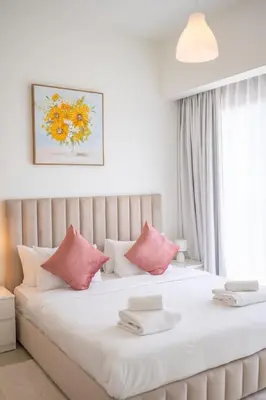 a bedroom with a large white bed with pink pillows at Downtown Escape 2bedroom Apartment 4 guests Dubai in Dubai