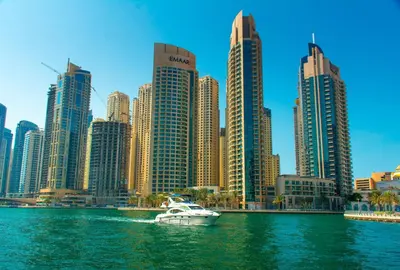 a boat in the water in front of a city at Apartments on Marina in Dubai