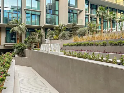 a building with a garden in front of it at Modern Studio Near Burj Khalifa & Dubai Mall with Pool, Gym, Concierge & Parking in Dubai