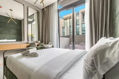 a bedroom with a bed and a large window at Modern Studio Near Burj Khalifa & Dubai Mall with Pool, Gym, Concierge & Parking in Dubai