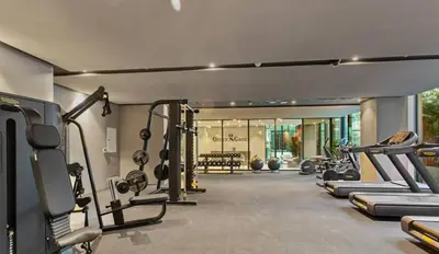 a gym with a row of treadmills and machines at Modern Studio Near Burj Khalifa & Dubai Mall with Pool, Gym, Concierge & Parking in Dubai
