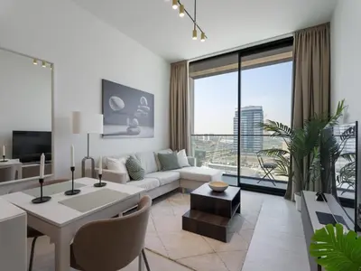 a living room with a couch and a table at Luxe Escape - Stylish 1BR in Binghatti Venus-05 in Dubai