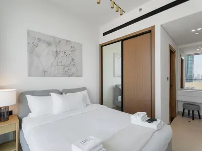 a bedroom with a white bed and a window at Luxe Escape - Stylish 1BR in Binghatti Venus-05 in Dubai