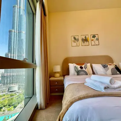 a bedroom with two beds and a large window at Grande Signature Burj Khalifa view 4 Min walk Dubai Mall Infinity Pool with Fountain View Free parking By The Meridian in Dubai
