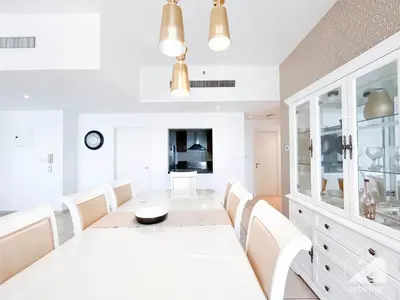 a white dining room with a white table and white chairs at Stunning 4 bedroom with Breathtaking Sea View JBR in Dubai