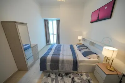 a bedroom with a large bed and a mirror at Luxury 2-Bedroom Stay in the Heart of Churchill in Dubai