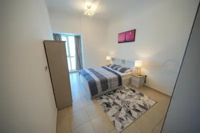 a small bedroom with a bed and a window at Luxury 2-Bedroom Stay in the Heart of Churchill in Dubai
