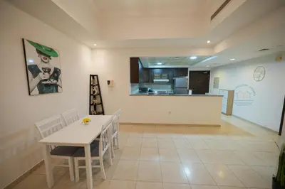 a kitchen and dining room with a table and chairs at Luxury 2-Bedroom Stay in the Heart of Churchill in Dubai