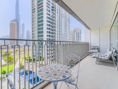 a balcony with a table and chairs and a view of a city at TRPS - Downtown Views II Tower 2, Downtown Dubai - 3BR plus Maids - Stylish Apartment Near Burj Khalifa & Attractions in Dubai