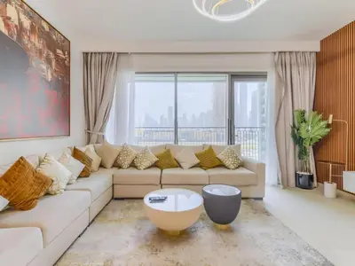 a living room with a white couch and a large window at TRPS - Downtown Views II Tower 2, Downtown Dubai - 3BR plus Maids - Stylish Apartment Near Burj Khalifa & Attractions in Dubai