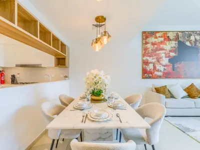 a dining room with a white table and chairs at TRPS - Downtown Views II Tower 2, Downtown Dubai - 3BR plus Maids - Stylish Apartment Near Burj Khalifa & Attractions in Dubai