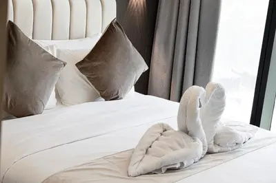 a bed with two swans made out of towels at SkyHigh Stay, Panoramic Sea Views & Beach Access in Dubai