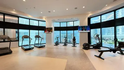 a gym with treadmills and ellipticals in a building at SkyHigh Stay, Panoramic Sea Views & Beach Access in Dubai