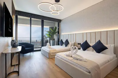 a hotel room with two swans on a bed at SkyHigh Stay, Panoramic Sea Views & Beach Access in Dubai