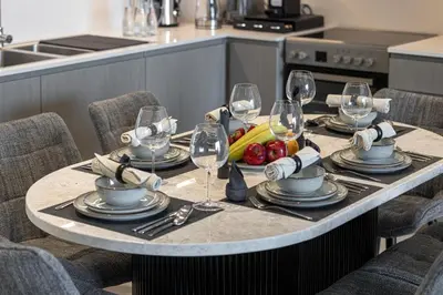 a table set with wine glasses and food on it at Luxury 2BR Sea View Walk to Burj & Dubai Mall in Dubai