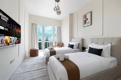 a hotel room with two beds and a tv at Luxury 2BR Sea View Walk to Burj & Dubai Mall in Dubai