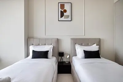 two beds sitting next to each other in a bedroom at Luxury 2BR Sea View Walk to Burj & Dubai Mall in Dubai