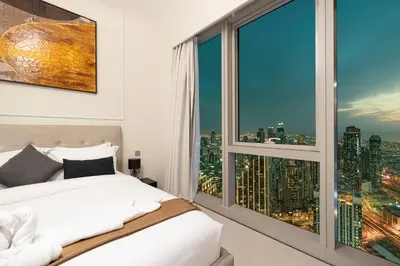 a bedroom with a large window with a city view at Luxury 2BR Sea View Walk to Burj & Dubai Mall in Dubai