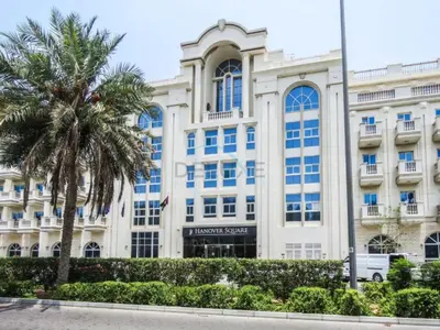 a building with a palm tree in front of it at Studio with Balcony Overlooking the Community, Walking Distance from the Park, Hanover Square HSS, Jumeirah Village Circle by Deluxe Holiday Homes in Dubai
