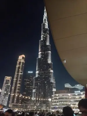a crowd of people standing in front of a tall building at Dubai dream in Dubai