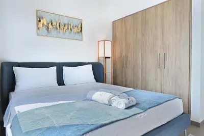 a bedroom with a bed with a wooden cabinet at Air Homes - Stylish 2BR Near Dubai Hills Mall & Park in Dubai