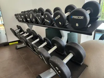 a row of dumbbells on shelves in a gym at Air Homes - Stylish 2BR Near Dubai Hills Mall & Park in Dubai