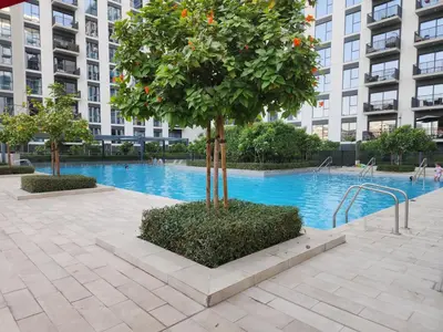 a tree in the middle of a swimming pool at Air Homes - Stylish 2BR Near Dubai Hills Mall & Park in Dubai