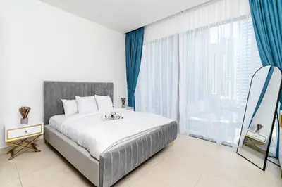 a bedroom with a bed and a large window at Contemporary Comfort - Serenity - Pool View in Dubai