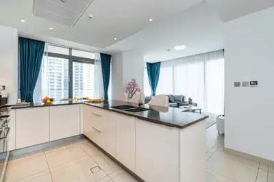 a kitchen with white cabinets and blue drapes at Contemporary Comfort - Serenity - Pool View in Dubai