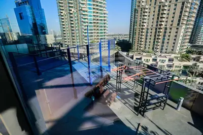 a person standing on a balcony of a building at Contemporary Comfort - Serenity - Pool View in Dubai