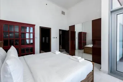 a bedroom with a white bed and a mirror at Cayan Tower Dubai Marina - Mint Stay in Dubai