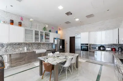 a kitchen with white cabinets and a table with chairs at Cayan Tower Dubai Marina - Mint Stay in Dubai