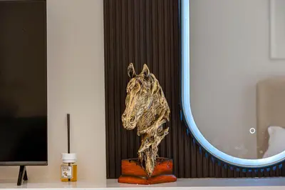 a bronze horse head on a table next to a mirror at Cozy And Contemporary Studio In Dubailand in Dubai