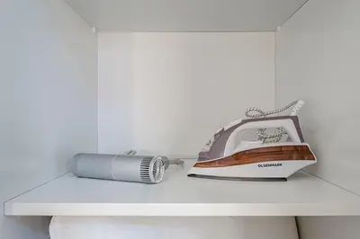a tea kettle and a roll on a shelf at Cozy And Contemporary Studio In Dubailand in Dubai