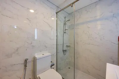 a bathroom with a toilet and a glass shower at Cozy And Contemporary Studio In Dubailand in Dubai