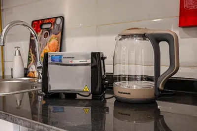 a blender sitting on a kitchen counter next to a sink at Cozy And Contemporary Studio In Dubailand in Dubai