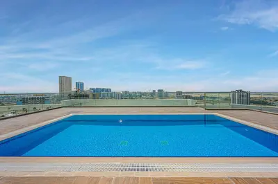 a swimming pool on the roof of a building at Cozy And Contemporary Studio In Dubailand in Dubai