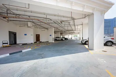 an empty parking lot with cars parked in it at Cozy And Contemporary Studio In Dubailand in Dubai