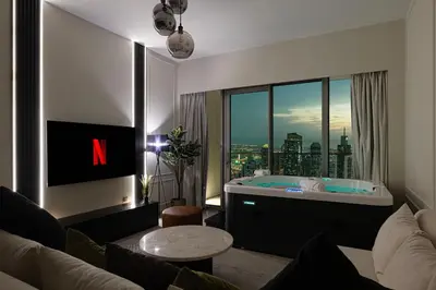 a living room with a tub with a view of the city at Luxury2BR Sea View Hot Tub Walk to Burj Dubai Mall in Dubai