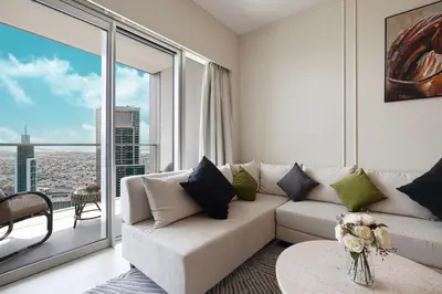 a living room with a couch and a large window at Luxury2BR Sea View Hot Tub Walk to Burj Dubai Mall in Dubai